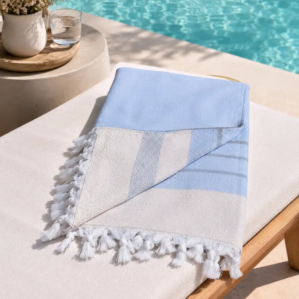 Fouta_bleu_ciel_coton_turc_avec_envers_eponge_et_franges_a_pompons_serviette_hammam_au_bord_de_la_piscine
